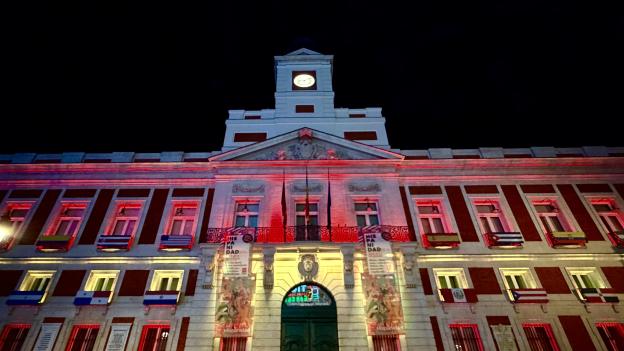 La Comunidad de Madrid ilumina la Real Casa de Correos con los colores de la bandera de España para conmemorar la Fiesta Nacional